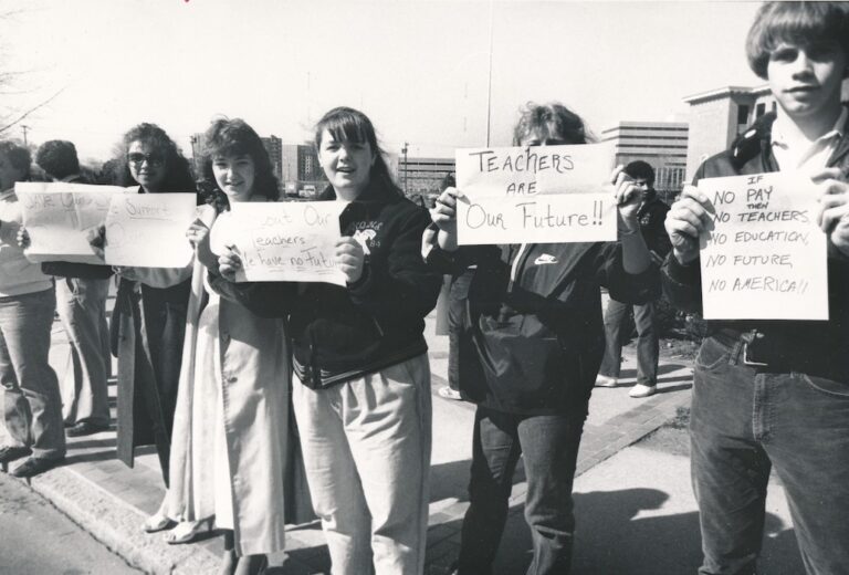 Line of people holding signs supporting strike.