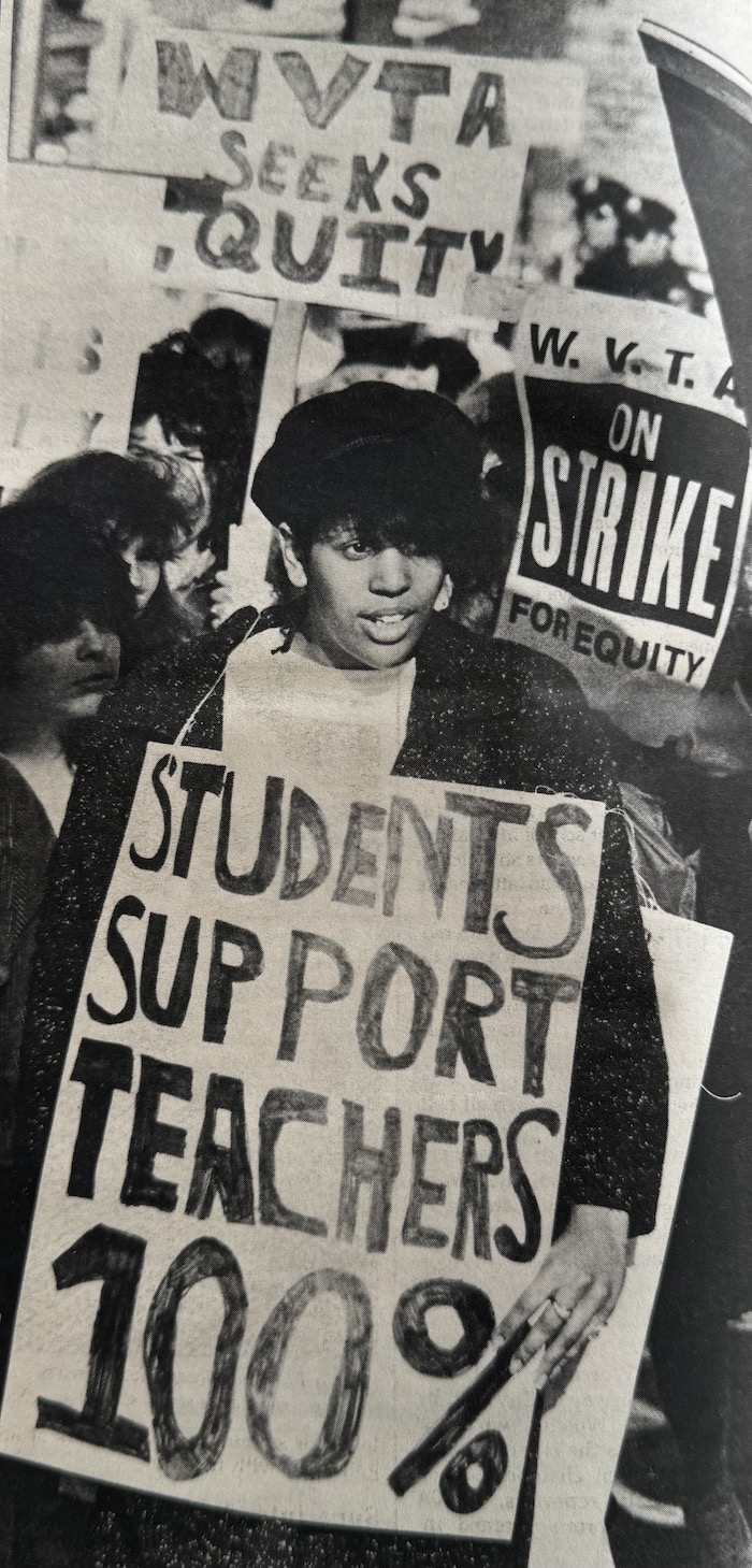 Picketer in crowd with sign supporting the WVTA strike.