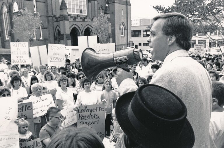 Richard Liston in front of crowd with bullhorn.