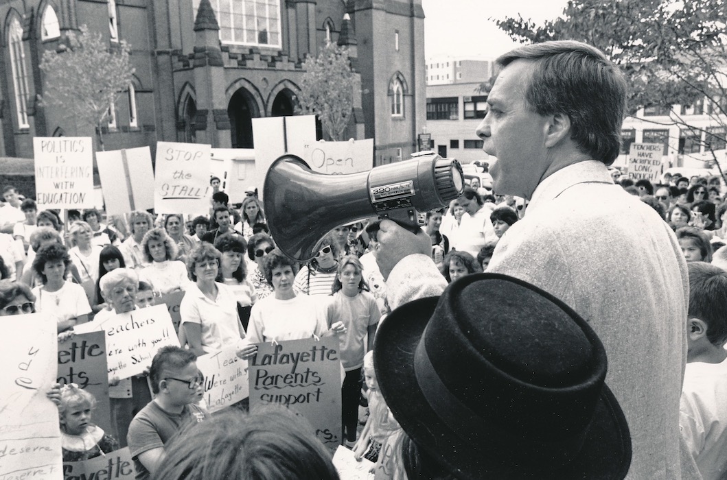 Richard Liston in front of crowd with bullhorn.
