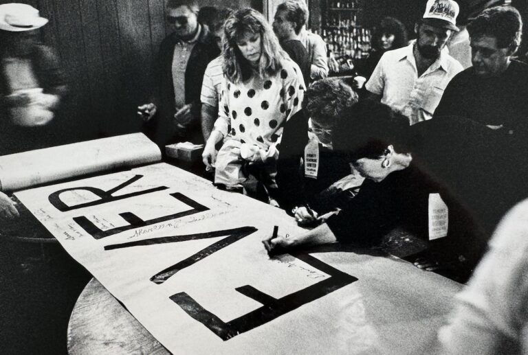 Group of people signing a banner.