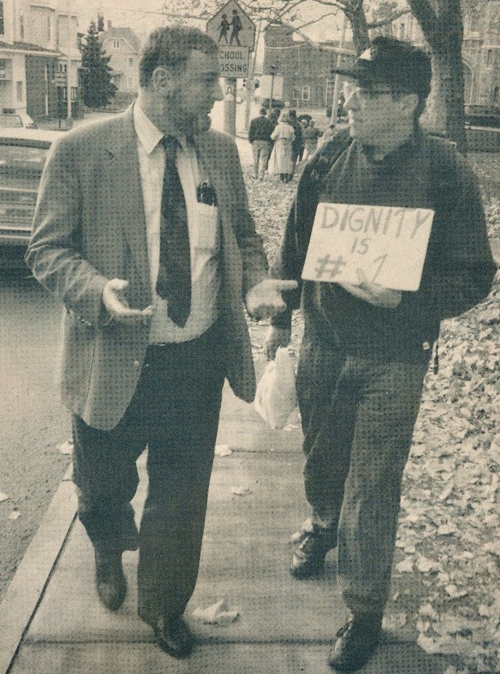 Two people talking on the picket line, one holding a sign supporting the Brockton strike.