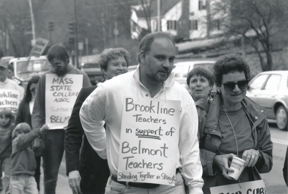 Picketers wearing signs supporting the Belmont strike.
