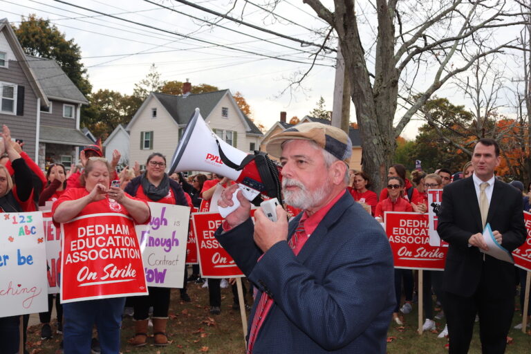 Tim Dwyer standing in front of a crowd holding a bullhorn.