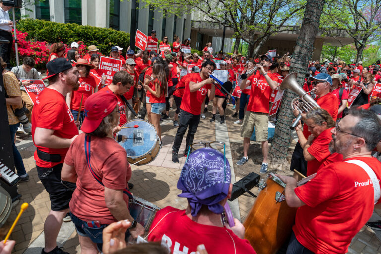 Musicians playing instruments in crowd of picketers.