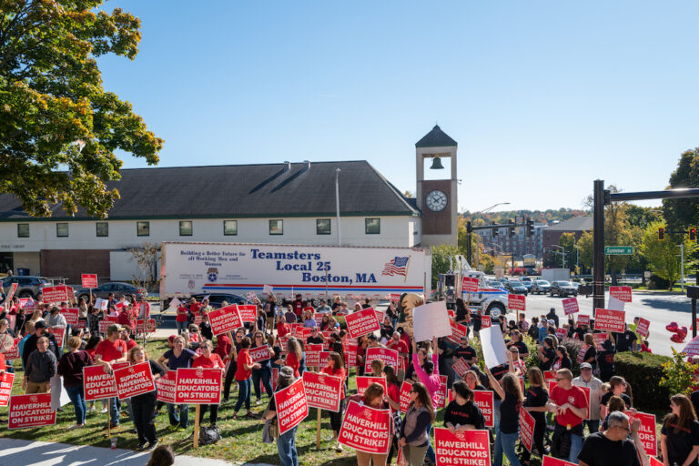 Crowd of picketers with Teamsters Local 25 truck behind them.