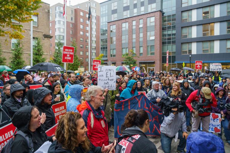 Crowd of picketers in rain.