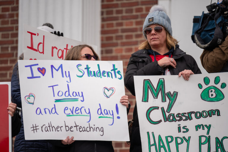 Two teachers hold signs in support of Andover strike.