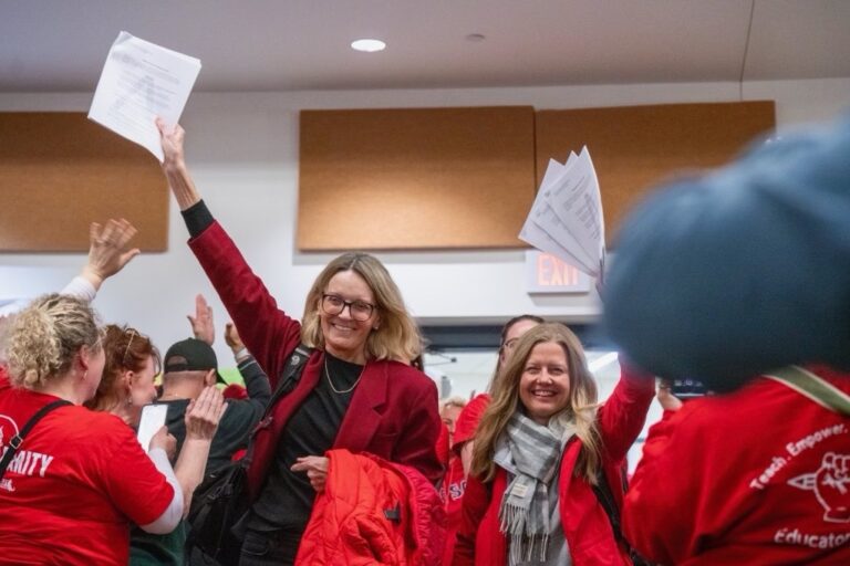 Julia Brotherton and Andrea Sherman holding up the new contract while surrounded by other BTA members.