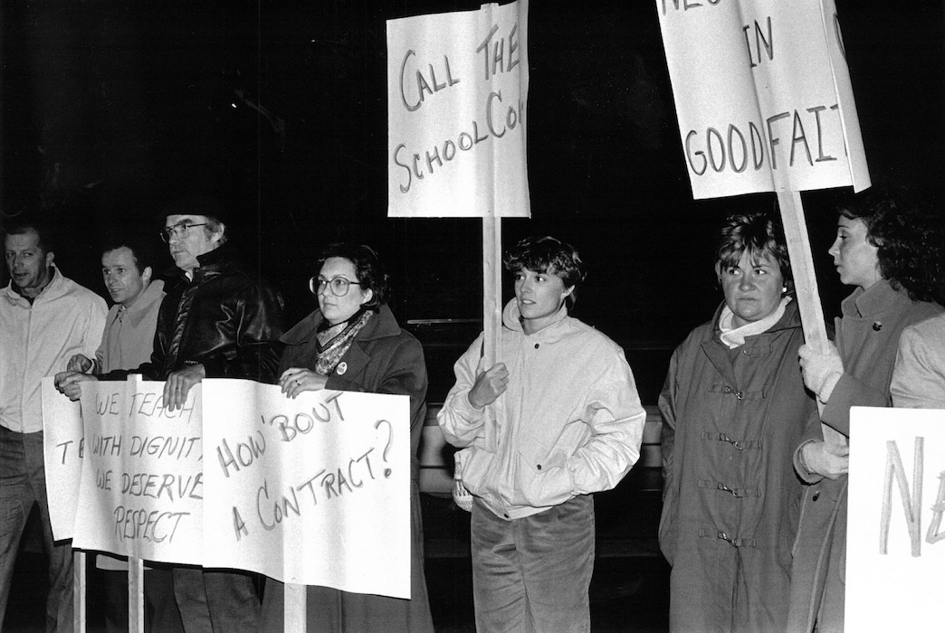 Line of people holding signs supporting Attleboro strike.