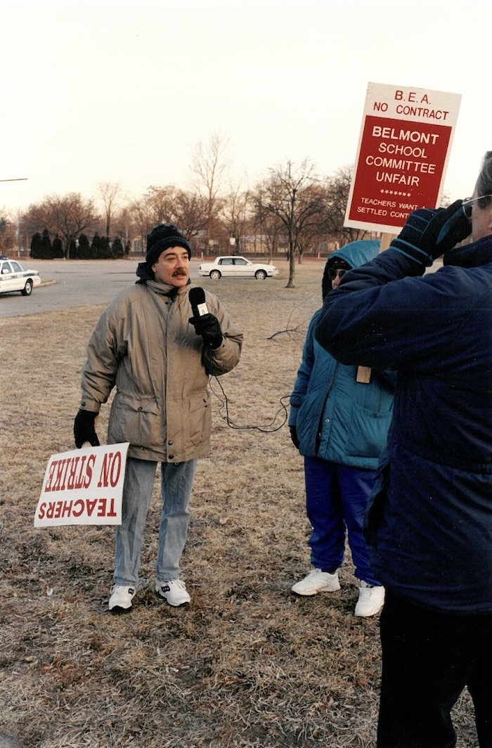 Person holding a sign and microphone.