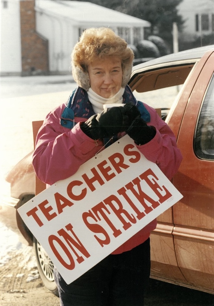Picketer with sign supporting the Belmont strike.