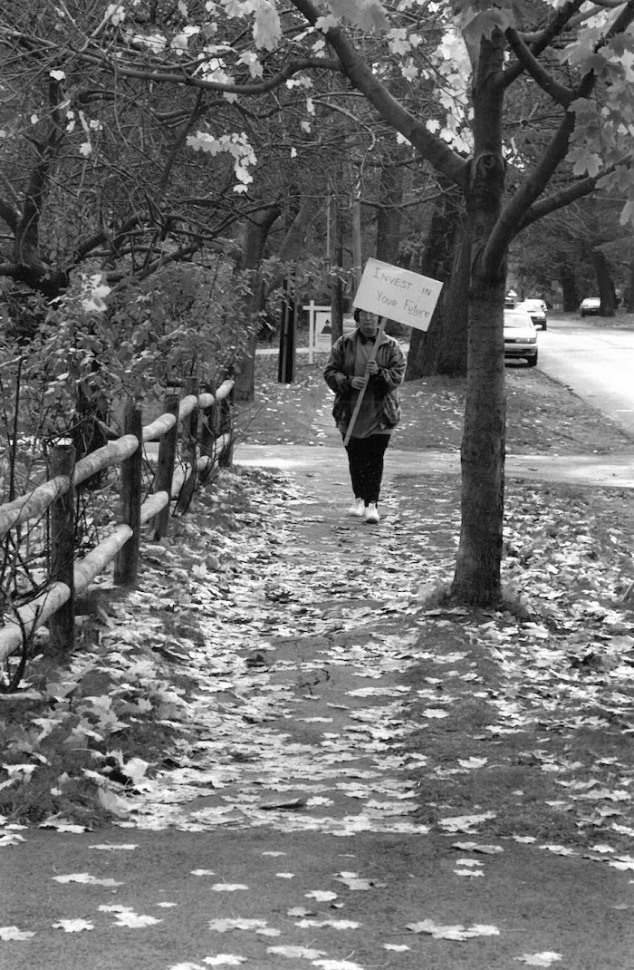 Picketer holding sign supporting the Beverly strike on a sidewalk.