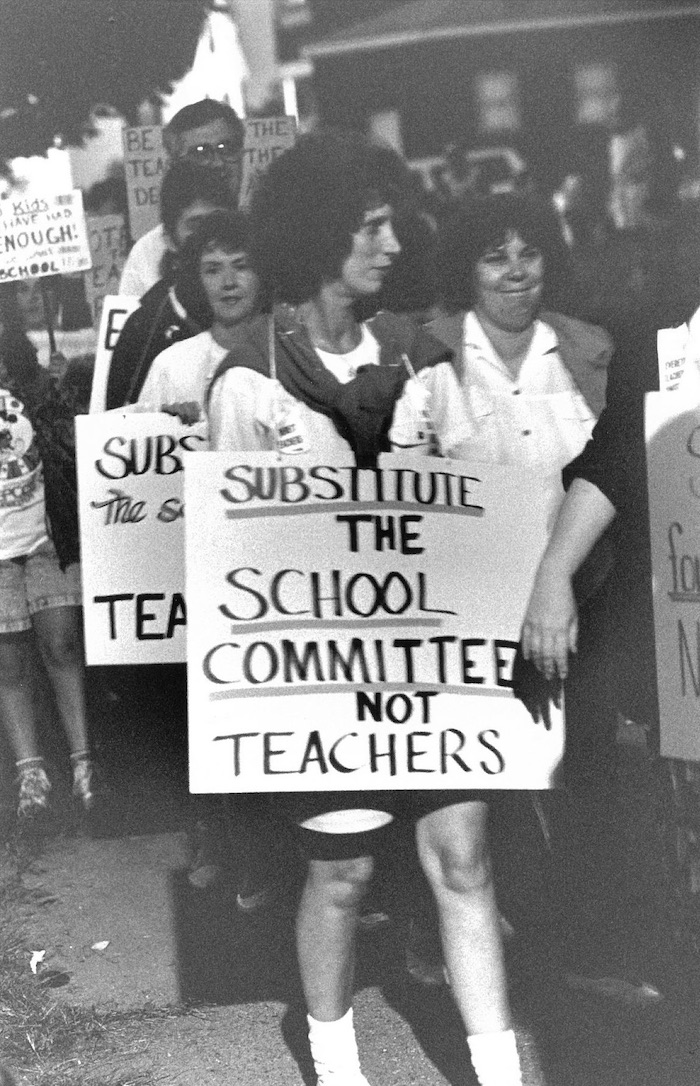 Picketer with sign in crowded picket line.
