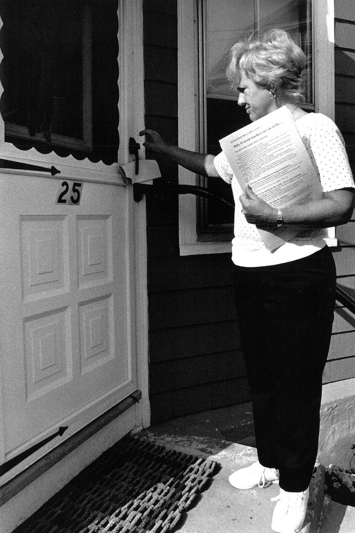 Woman leaving flyer at a door.