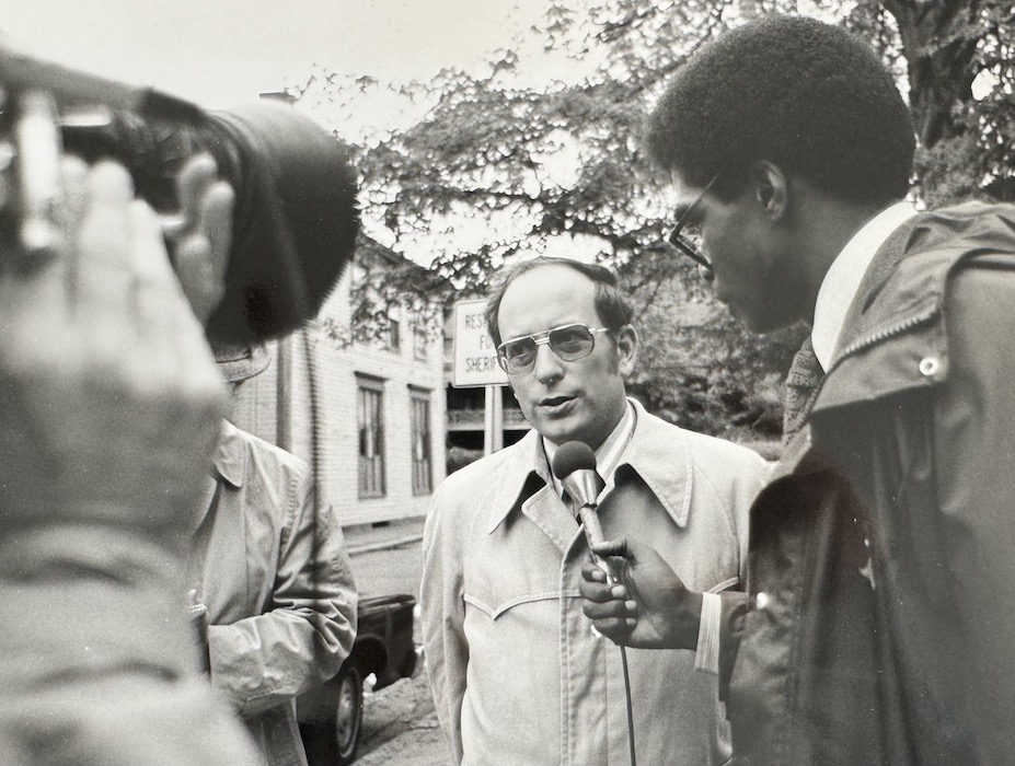 Camera man and reporter interviewing man.