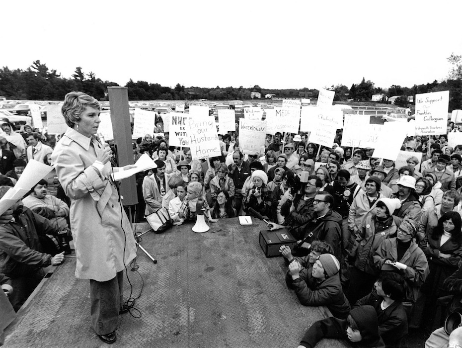 Woman with microphone speaking in front of a crowd holding signs supporting the Franklin strike.