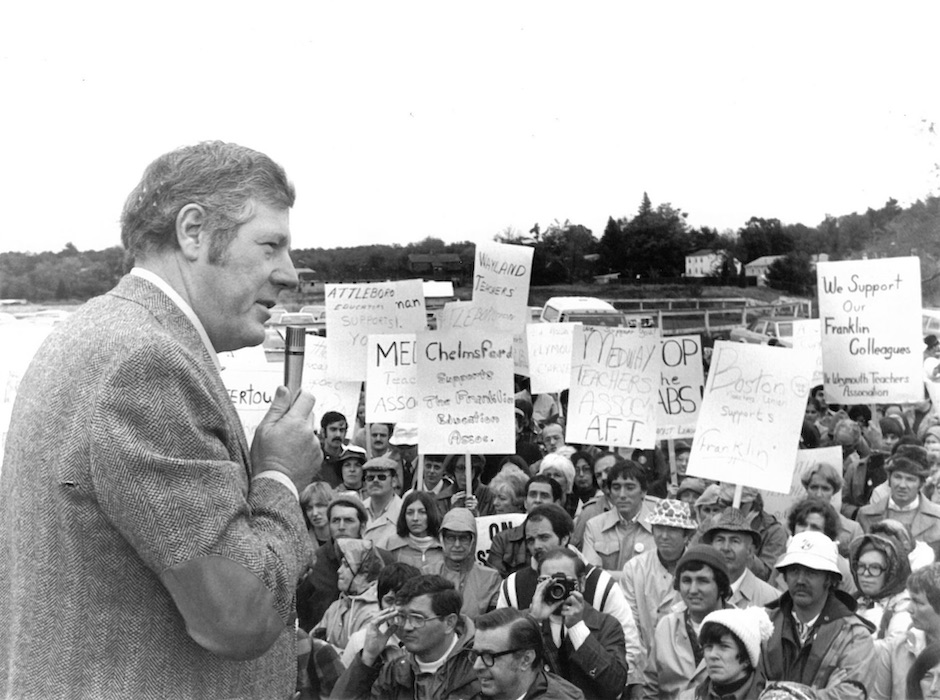 Man with microphone speaking in front of a crowd holding signs supporting the Franklin strike.