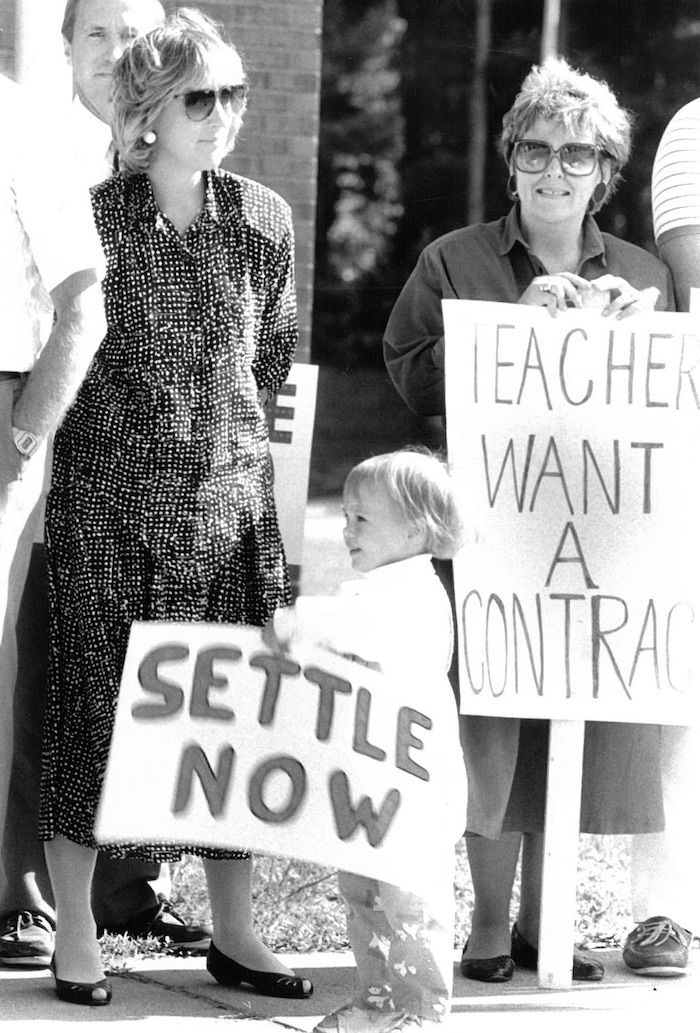 Small child holding sign supporting Hanover strike in picket line.