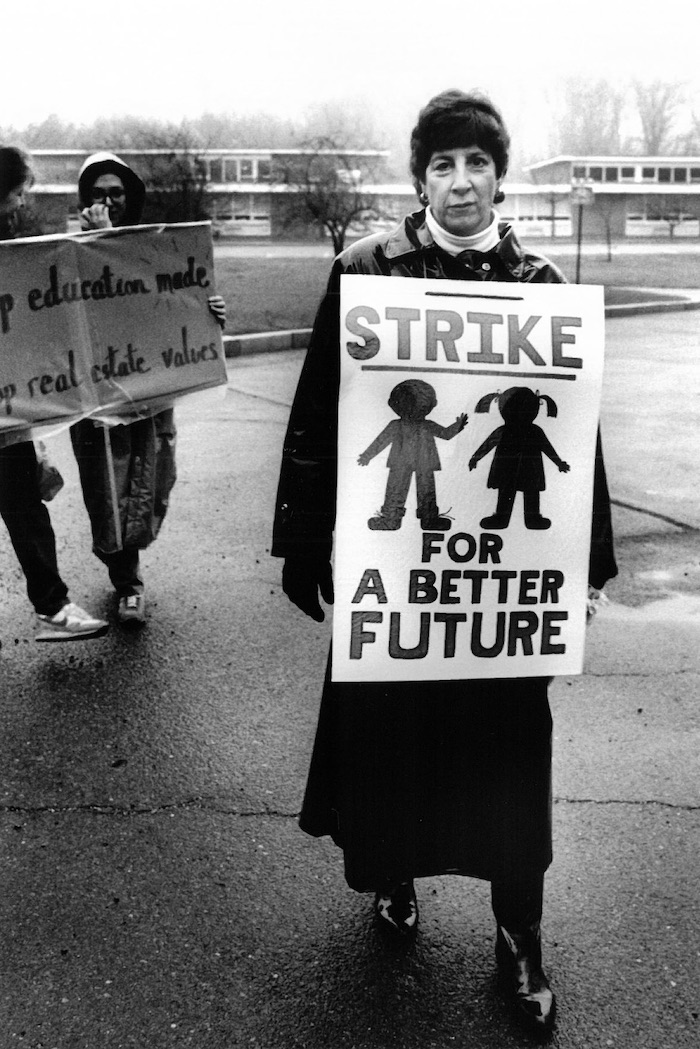 Picketer wearing a sign supporting the Lexington strike.