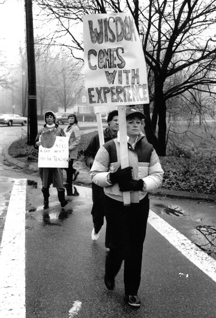 Picketers crossing a street with signs supporting the Lexington strike.