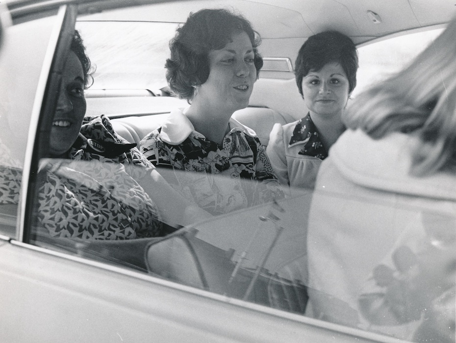 Women in the backseat of a car.
