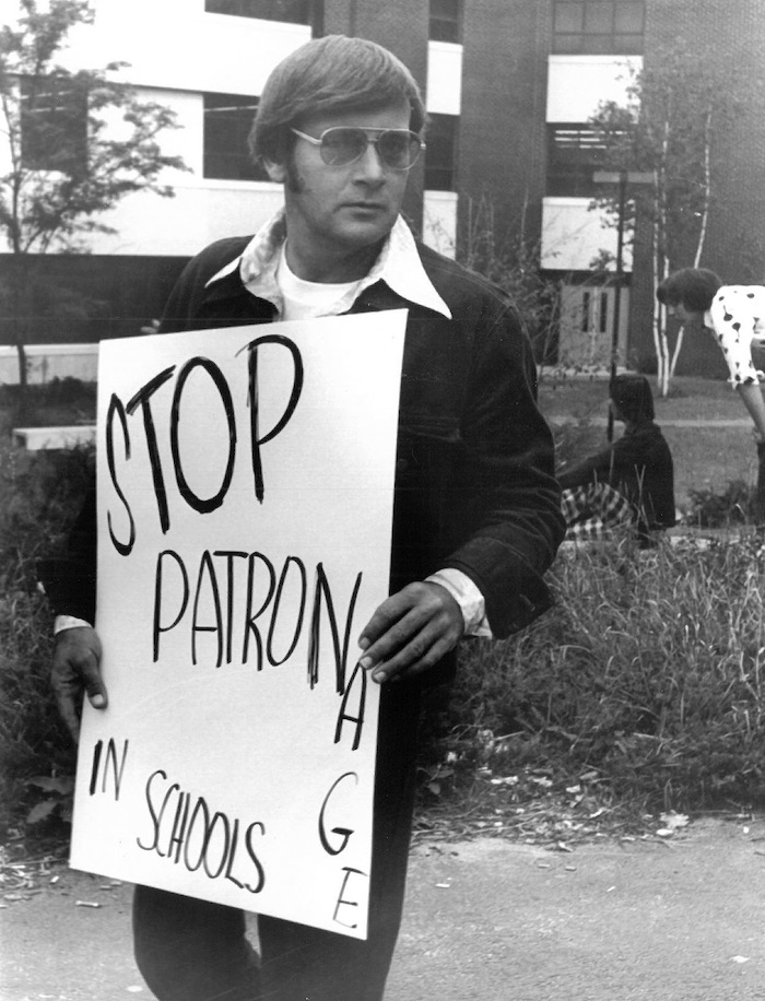 Picketer with sign supporting the New Bedford strike.