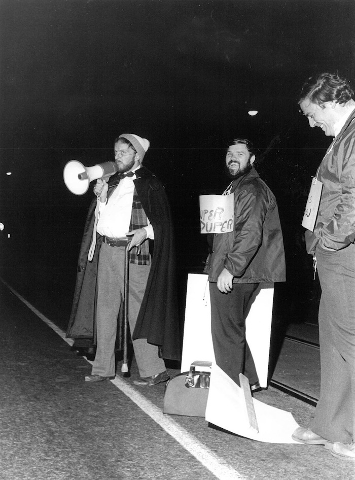 Three picketers, one with a bullhorn, with signs supporting the New Bedford strike.