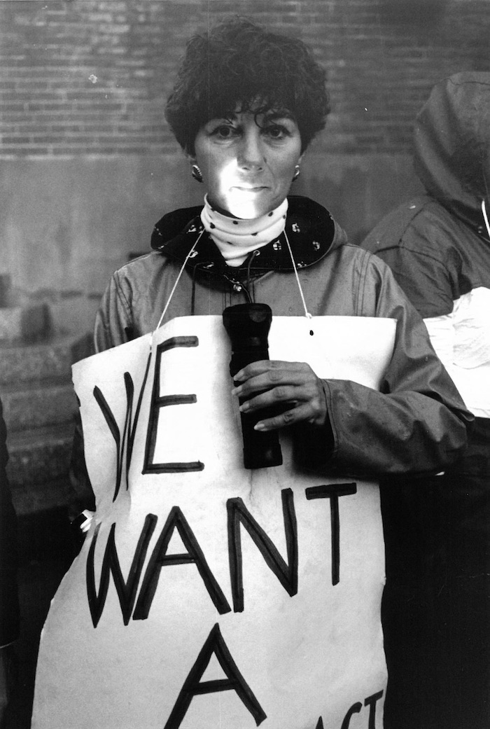 Picketer wearing a sign supporting the Norton strike.