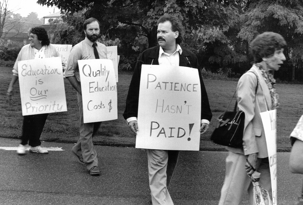 Picketers with signs supporting the Norton strike.