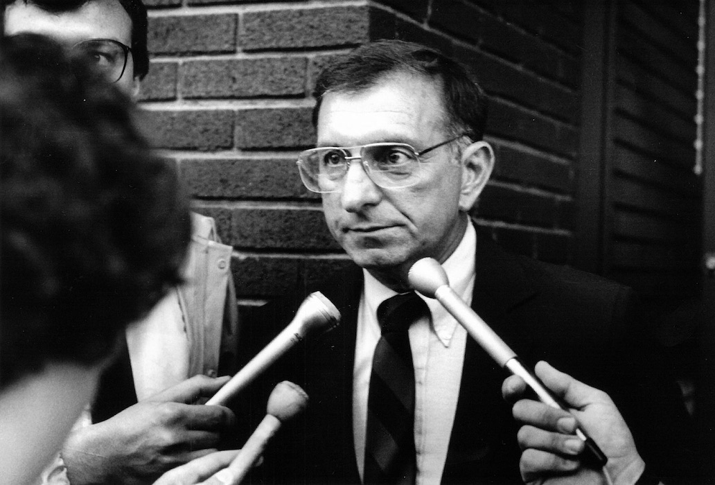 Multiple microphones being held in front of Richard Champa.