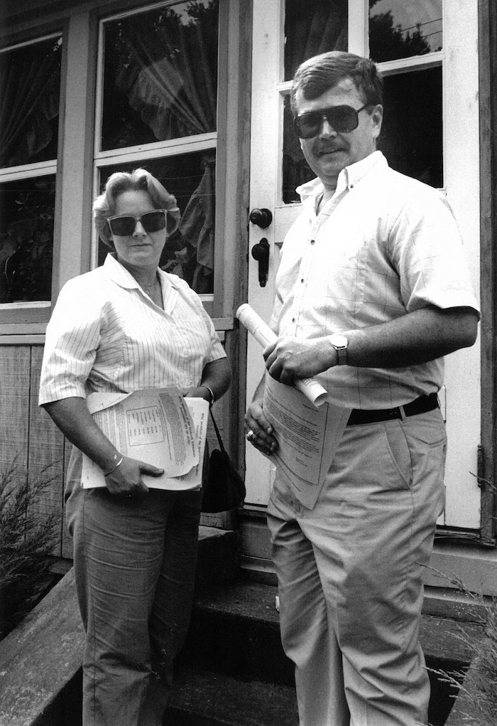 Two people standing outside of a door.