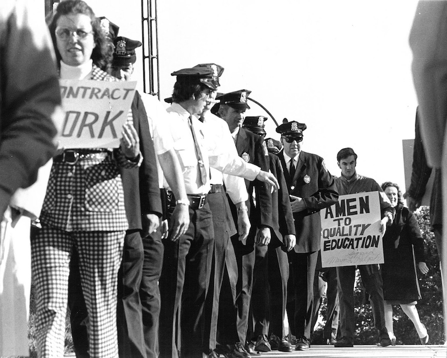 Crowded picket line including police officers.