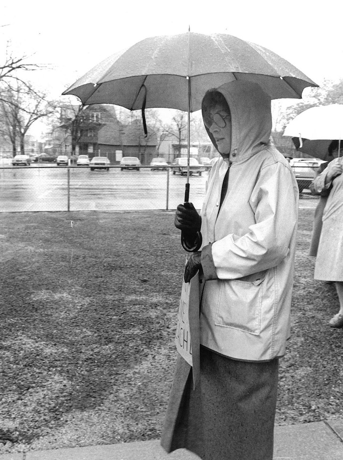 Picketer holding an umbrella in the rain.