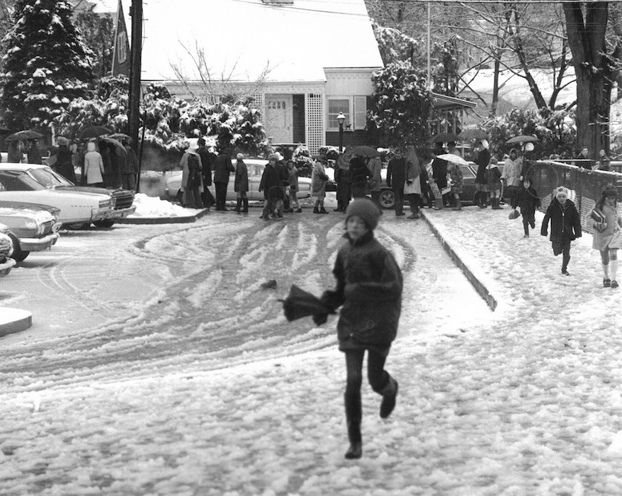 Picket line in the snow with children running in front of them.