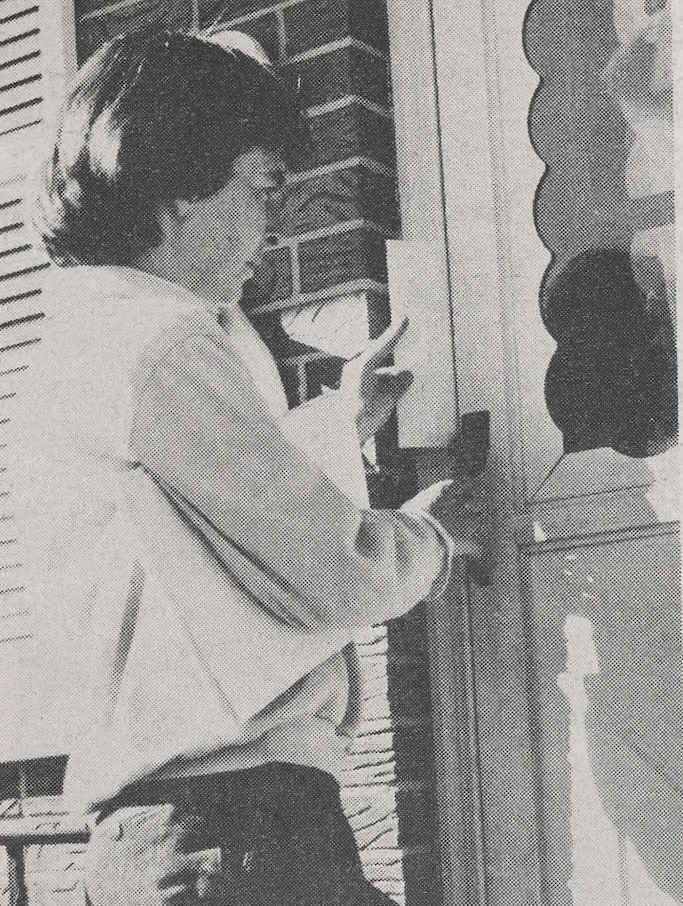Elaine Gardner leaving a flyer at a door.