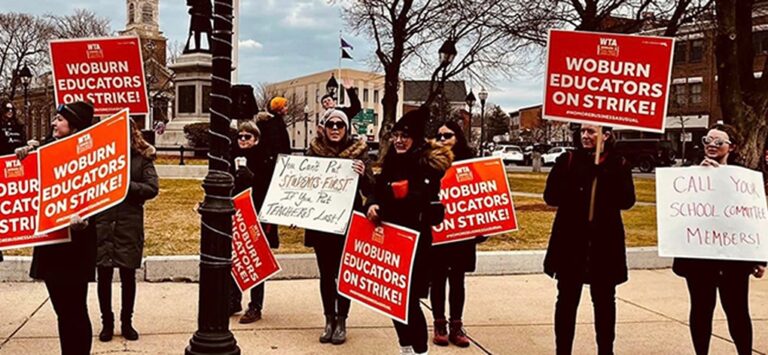 Photo from 2023 Woburn Strike of teachers picketing and holding signs.
